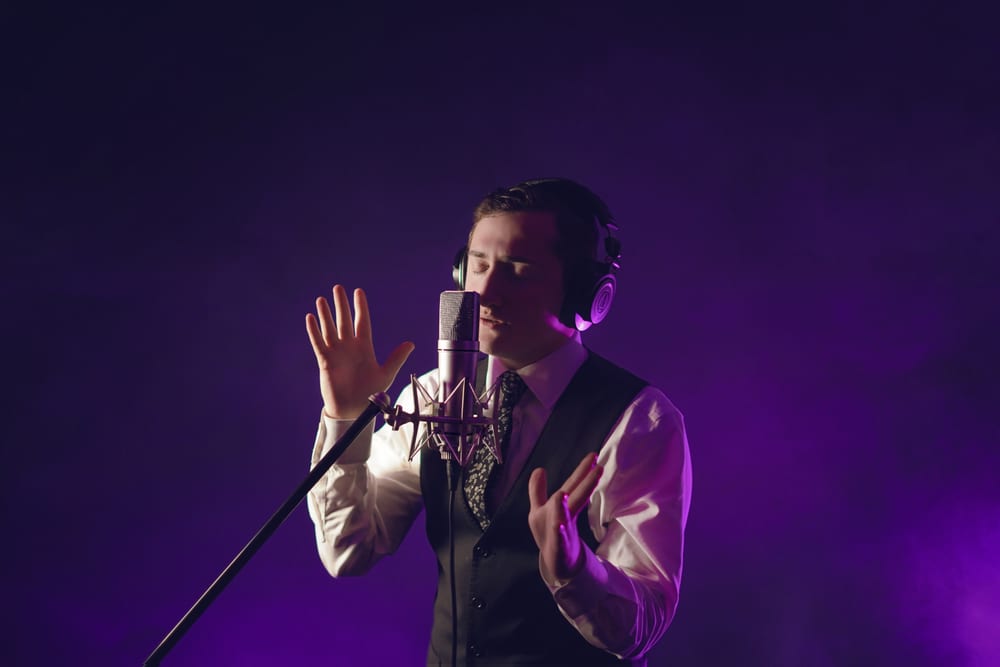 Dovid Pearlman singing into a studio microphone
